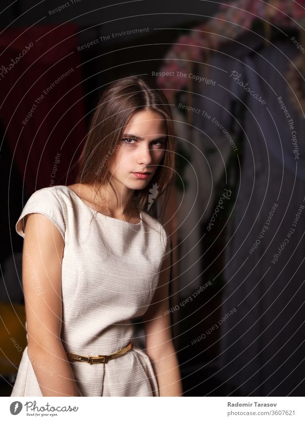 Porträt eines schönen brünetten jungen Mädchens in hellem Kleid auf dunklem Hintergrund im Atelier Schönheit Frau Kaukasier Menschen attraktiv Person Auge