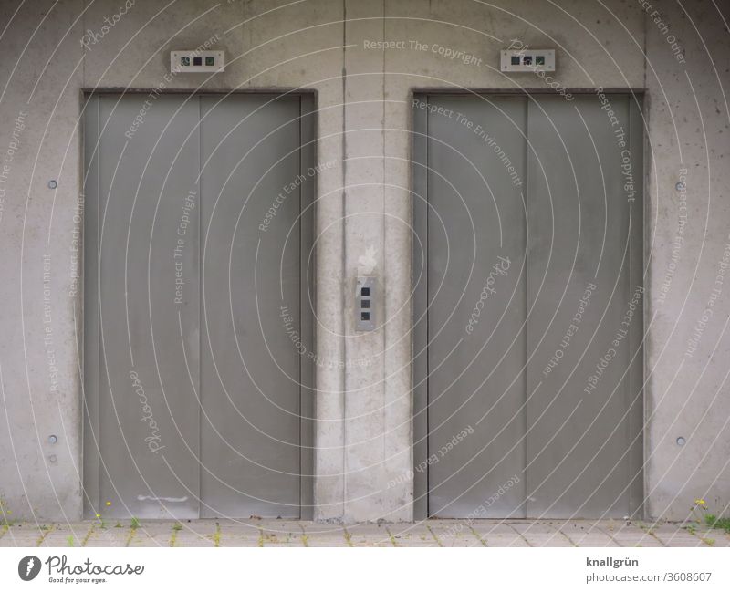 Zwei schmale, geschlossene Aufzugtüren Fahrstuhl Tür zwei Beton Architektur Außenaufnahme Gebäude grau Menschenleer Wand trist Gedeckte Farben Farbfoto Mauer