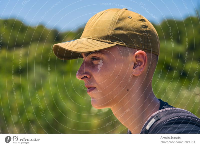 Porträt eines jungen Mannes mit Basecap im Profil zielen Rucksack Baseballmütze Strand schön Junge lässig Kaukasier selbstbewusst Abend Tor grün Reise Lifestyle