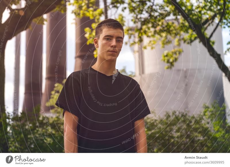 Porträt eines ernsten jungen Mannes vor einer Industrieanlage Jugendlicher schön Junge Gebäude lässig Kaukasier Schornstein selbstbewusst Kultur Einrichtung