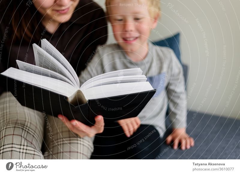 Mutter und Kind lesen Buch und lächeln Familie heimwärts Zusammensein Glück Kindheit Menschen Eltern Frau Kaukasier Bildung Fröhlichkeit im Innenbereich Mama