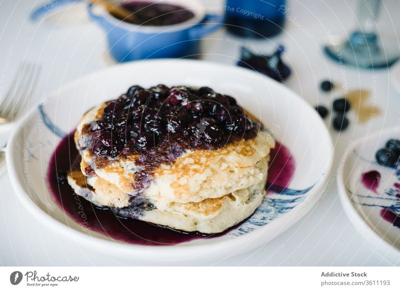 Pfannkuchen mit Marmelade bei Tisch zu Hause Brunch Frühstück Blaubeeren essen selbstgemacht Lebensmittel lecker Portion geschnitten Morgen geschmackvoll