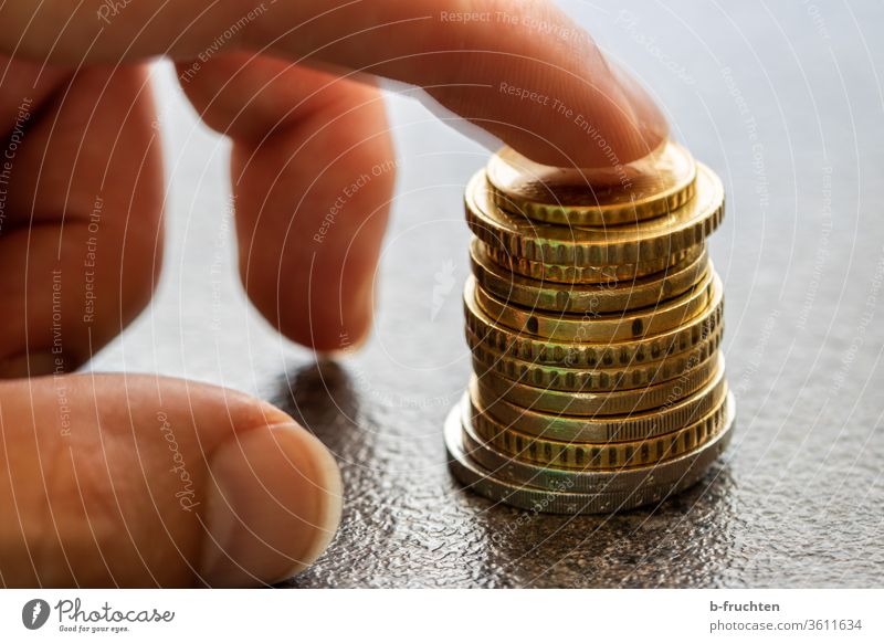 Ein Stapel Euro-Münzen münzen Geld Bargeld Geldmünzen bezahlen sparen Einkommen Kapitalwirtschaft Wirtschaft Investition Hand Finger Zeigefinger halten