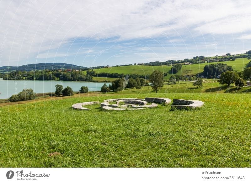 Steinskulptur am See, Landschaft Wasser ruhig Himmel Österreich Salzkammergut Irrsee Sommer Wiese Skulptur panorama Seeufer Natur Menschenleer