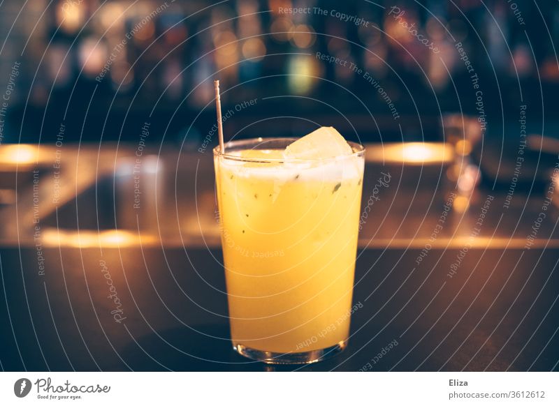 Ein Cocktail auf dem Tresen einer Bar Drink Limonade Getränk orange Eiswürfel abends Alkohol ausgehen Erfrischungsgetränk Longdrink Glas Cocktailbar lecker