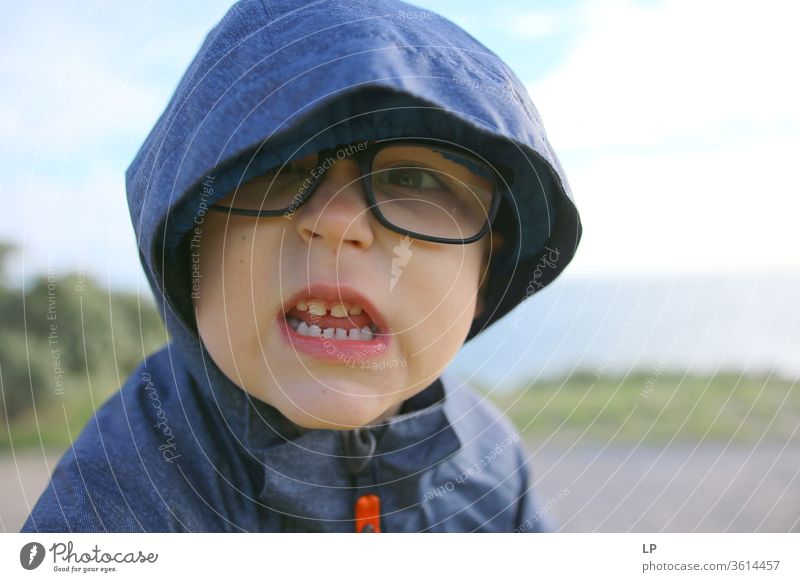 wütender kleiner Junge Zähne zeigend Gebiss Zahnarzt Biss Nahaufnahme Zahnpflege Zahnmedizin gefährlich verärgert kämpfen Feindseligkeit Kapuze Brille Blick