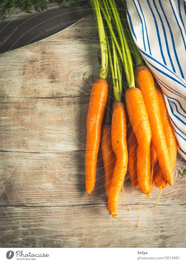 Rohe Karotten auf rustikalem Holzgrund Möhre Gemüse Koch Lebensmittel roh organisch Ernte Garten hölzern Tisch Serviette Textil Stoff essen Gesundheit ungekocht
