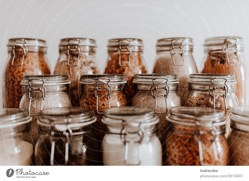 Glasbehälter voll mit getrockneten ungekochten Lebensmittelzutaten Container weiß vereinzelt Gesundheit Bestandteil Küche Produkt Überleben COVID Quarantäne