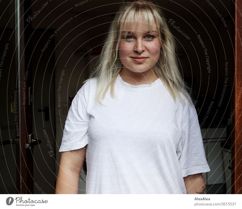 Portrait einer jungen blonden Frau in einem Türrahmen Mädchen junge Frau schön lächeln lange Haare blaue Augen Haut 19 18-20 Jahre 15-20 Jahre alt fit