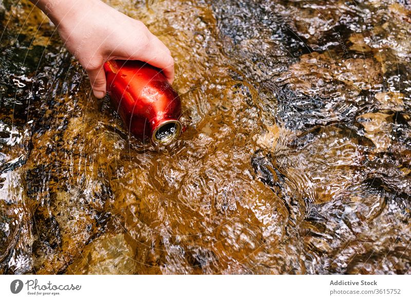 Anonyme Frau, die Wasser aus einem Bach im Wald entnimmt ruhen Flasche Sauberkeit Stil grün Oberbekleidung Natur sich[Akk] entspannen Lifestyle Landschaft