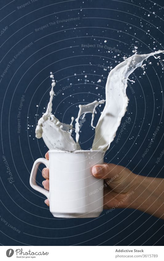 Frau mit einer Tasse spritzender Milch platschen melken frisch Molkerei Tropfen Getränk trinken Atelier liquide Bewegung sich[Akk] bewegen Becher Keramik