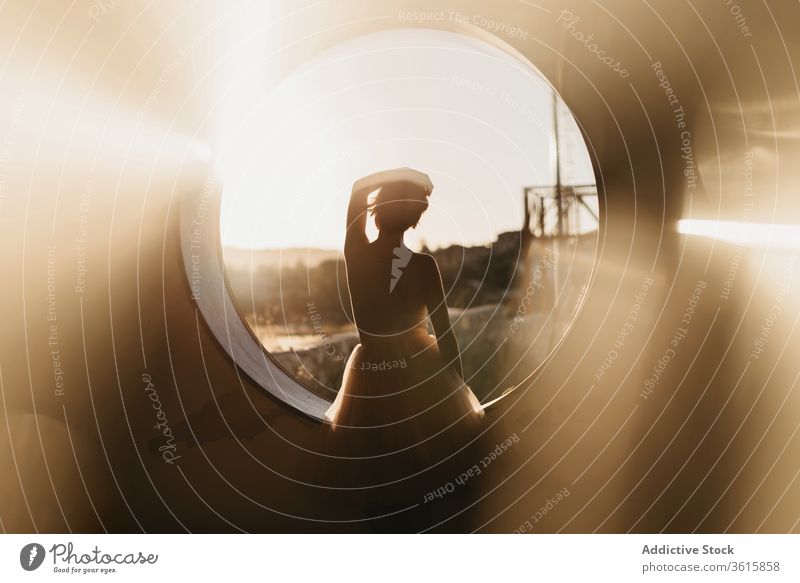 Entspannte Tänzerin schaut auf rundes Loch Frau Anmut sich[Akk] entspannen Silhouette träumen besinnlich Gelassenheit Kunst kreativ Golfloch Fenster Natur