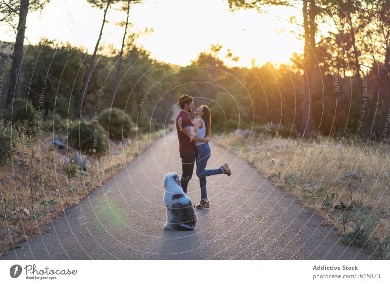 Ruhiges glückliches Paar mit Hund unterwegs ruhig Straße Sonnenuntergang Harmonie Zusammensein Einheit sich[Akk] entspannen stehen erstaunlich Freundin Fahrbahn