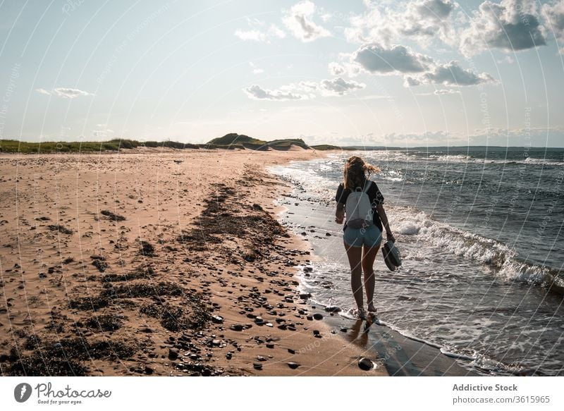 Reisende Frau geht am Meeresufer entlang Spaziergang Seeküste Urlaub Strand Tourist Sommer MEER sonnig reisen Barfuß Feiertag Ausflug Wochenende idyllisch