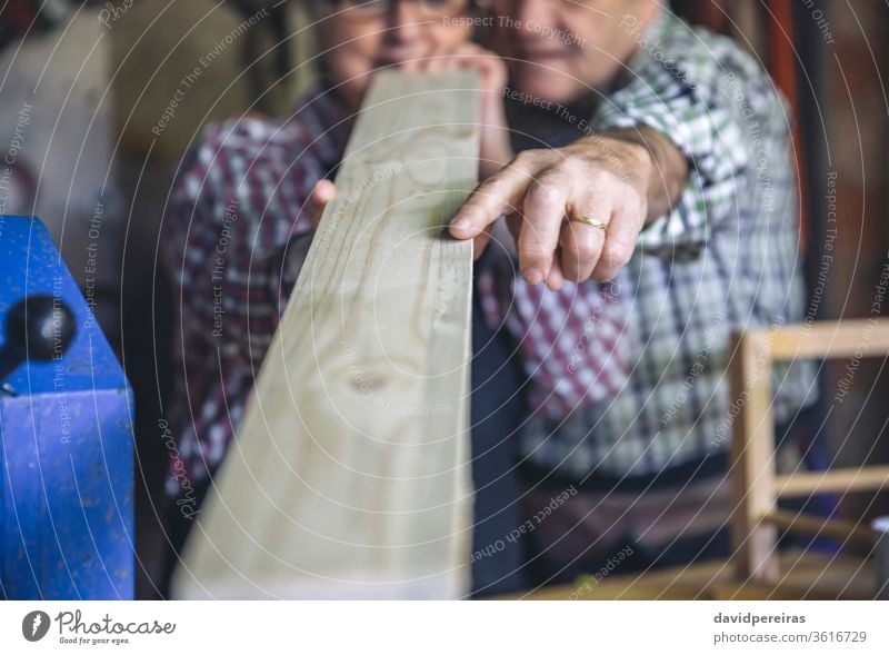 Seniorenpaar in einer Tischlerei unkenntlich Schreinerei Paar Hand Überprüfung Schiffsplanken Zeigen Detailaufnahme Holzlatte Werkstatt Zusammensein