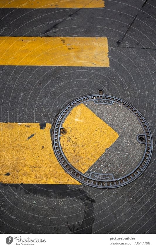 Zebrastreifen und Kanaldeckel Straße Straßenmarkierung Achtsamkeit inkorrekt Fahrbahnbelag gelb grau versetzt Vogelperspektive Asphalt Metall Verkehrswege