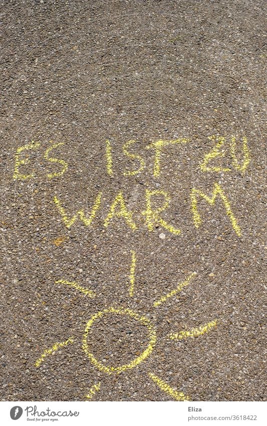 Mit Straßenmalkreide gemalte Sonne und der Text “es ist zu warm”. Konzept Klimaerwärmung, schwitzen und Hitze. Sonnenschein Kreidezeichnung Sommer Klimawandel