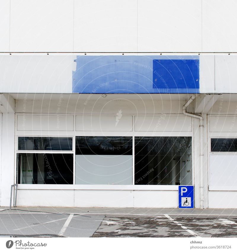 Fassade Fenster weiß blau Parkplatz Schilder & Markierungen Brüstungen Gewerbe Leerstand trist Tristesse Außenaufnahme Menschenleer Gebäude Bauwerk Mauer