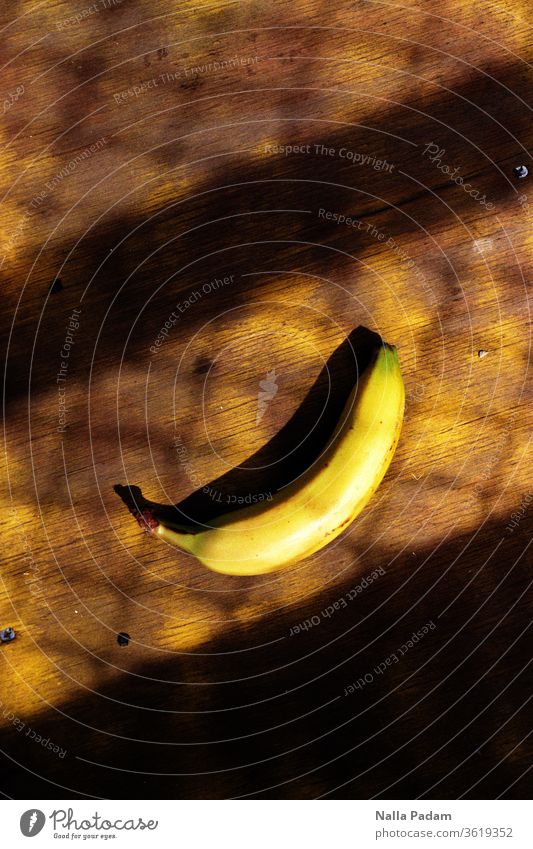 Banane räkelt sich im Schatten eines Gitters - Lost Banana in Folkestone Gelb Analogfoto analog krumm Außenaufnahme Frucht Tag Farbfoto Ernährung Lebensmittel