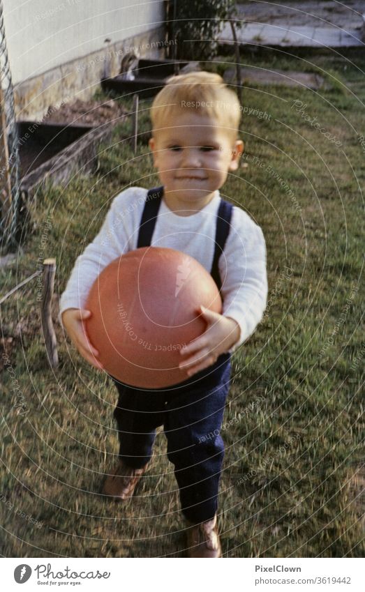 Ein kleiner Junge spielt mit dem Ball im Garten Kind Mensch Farbfoto Kindheit Spielen Fröhlichkeit Kleinkind niedlich Freude Glück ball