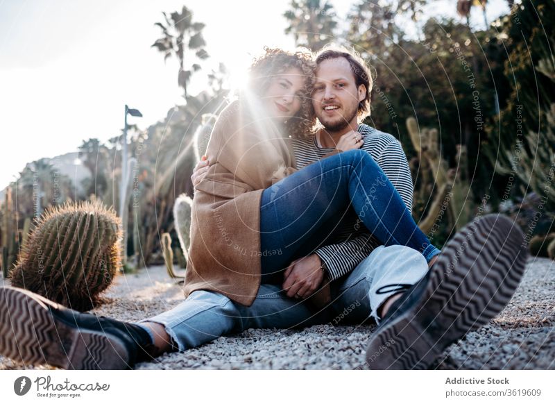 Glückliches Paar umarmt sich im Kaktuspark Umarmung Liebe Park sonnig tagsüber Barcelona Spanien Mann Frau aufgeregt Partnerschaft Umarmen heiter Sommer