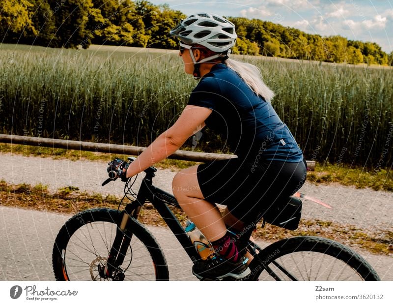 Junge Frau beim Mountainbiken mountainbike fahrrad sport sportlich athlet junge frau spaß bond helm trikot Außenaufnahme Fitness Fahrradfahren Gesundheit