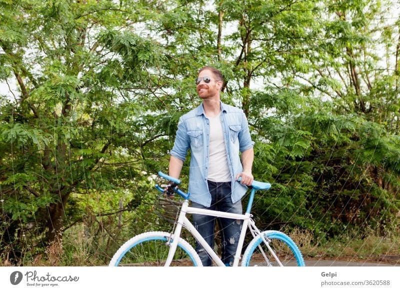 Hübscher Mann genießt mit seinem Fahrrad im Park lässig Lifestyle männlich Typ jung Freizeit Sommer Menschen aktiv Erwachsener Person urban genießen Kaukasier