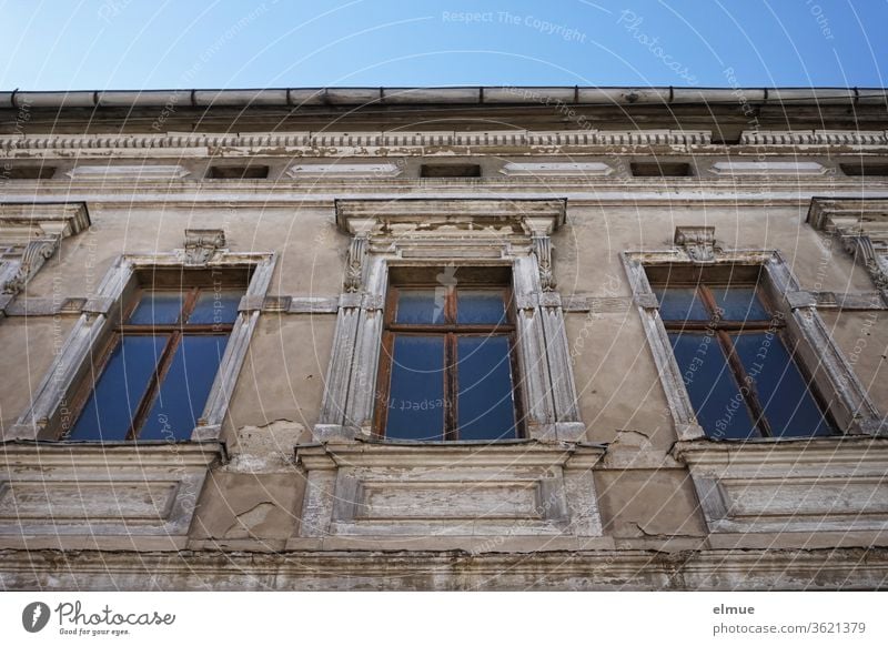Teilansicht eines maroden Gebäudes aus der Gründerzeit mit drei hohen Fenstern aus der Froschperspektive altes Gebäude wohnen kaputt Historismus Architektur