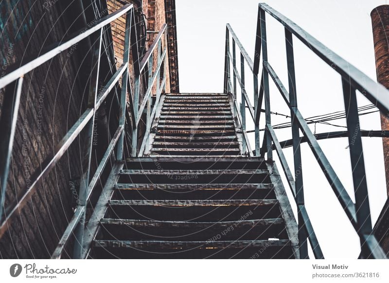 Verrostete Außentreppe einer alten, verlassenen Textilfabrik Fabrik Gebäude Verlassen rostig Treppe Treppenhaus schäbig metallisch Baustein Außenseite