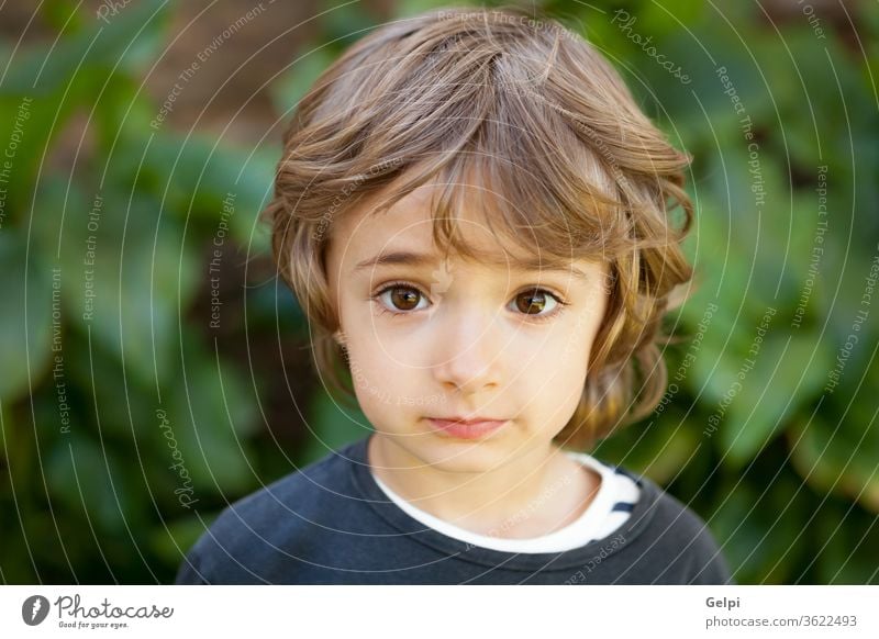 Porträt eines kleinen Kindes auf dem Feld außerhalb Lächeln Freude wenig Glück grün Junge Kaukasier Kindheit heiter Natur Frühling im Freien Baby Baum lustig