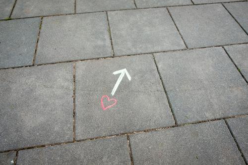 Ein Herz und ein Pfeil mit Kreide auf dem Boden gezeichnet Liebe Beziehung Wegweiser Richtung Gefühle Liebesleben Suche finden Zeichnung Konzept auf der Suche