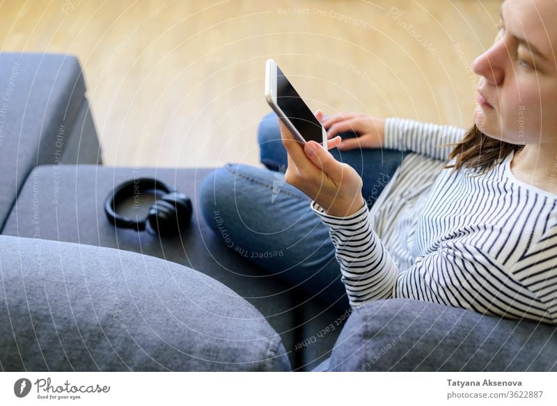 Frau benutzt Mobiltelefon auf der Couch online Telefon benutzend Sucht Internet Texten Surfen Bildschirm Smartphone heimwärts Mobile Technik & Technologie lesen