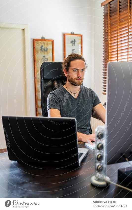 Hübscher Mann arbeitet zu Hause am Desktop-Computer Tippen Keyboard freiberuflich heimwärts abgelegen Arbeit benutzend männlich ernst Projekt beschäftigt