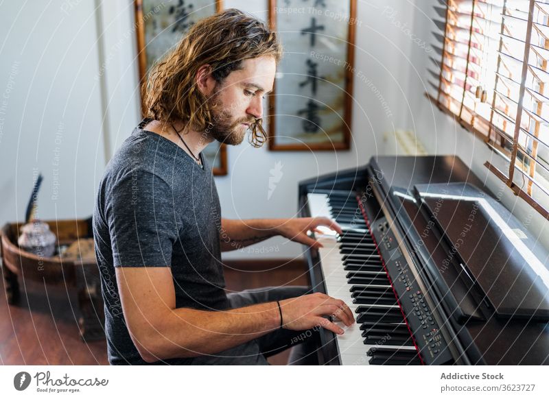 Talentierter Mann spielt zu Hause Klavier spielen Synthesizer Musiker Instrument heimwärts elektronisch männlich Fähigkeit Appartement gemütlich sitzen Melodie