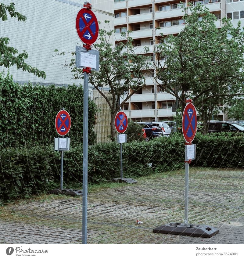 Halteverbot Schilder auf einem Parkplatz vor dem Fassaden von Hochhäusern in Berlin-Tegel Parkverbot Verkehrsschild Haus Hochhaus Wohnhaus rot blau grün Bäume