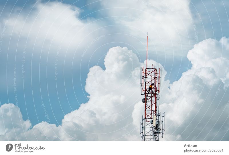 Fernmeldeturm mit blauem Himmel und weißen Wolken. Arbeiter installierte 5g-Ausrüstung am Telekommunikationsturm. Telekommunikationsindustrie. Mobiles oder Telekom 5g Netzwerk.