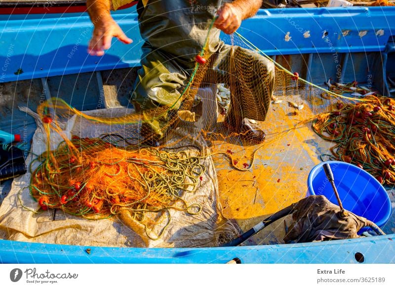 Fischer ist leerer Fisch aus dem Netz in seinem kleinen Boot Angeln einrichten Stiefel Haufen Boje fangen Cork Ziehen anstrengen einschließen Gerät Gewebe