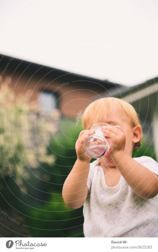 ein durstiges Kind trink draußen Wasser aus einem Glas trinkt trinken Junge Sommer sommerlich heiß Durstlöscher Getränk Erfrischungsgetränk Außenaufnahme