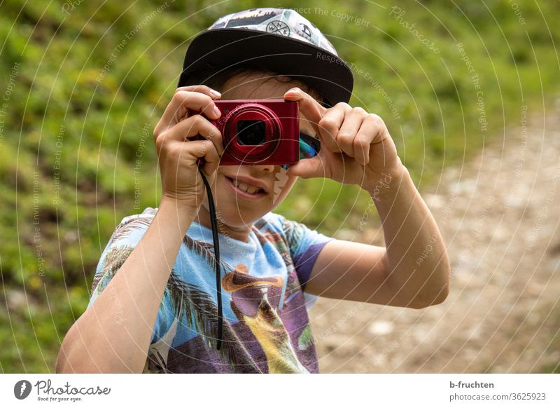 Kind mit Kamera macht ein Foto halten Außenaufnahme Kindheit 8-13 Jahre Blick in die Kamera Junge Porträt fotografieren