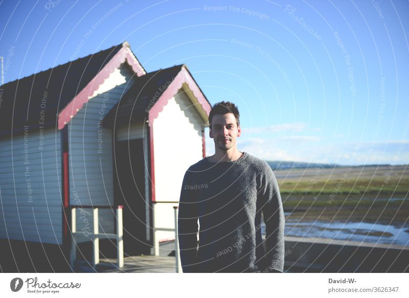 Mann steht draußen vor einer skandinavischen Holzhütter Holzhaus Urlaub Skandinavien Kanada Ferien & Urlaub & Reisen Erholung ruhe