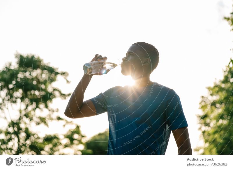 Sportlicher schwarzer Mann trinkt Wasser Afrikanisch trinken Fitness stark Biegung Körper passen Muskel Bizeps Waffen Athlet Stärke Lifestyle sportlich Training