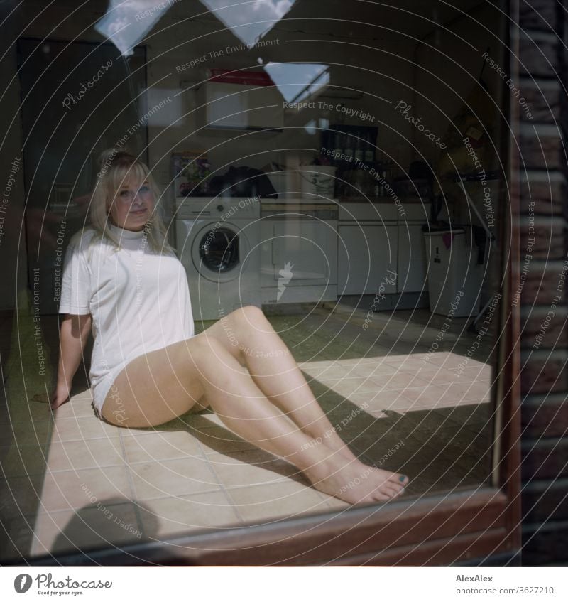 Analoges Portrait einer jungen Frau hinter einer Scheibe in einem Waschraum Mädchen junge Frau schön blond lange Haare 19 18-20 Jahre 15-20 Jahre alt fit