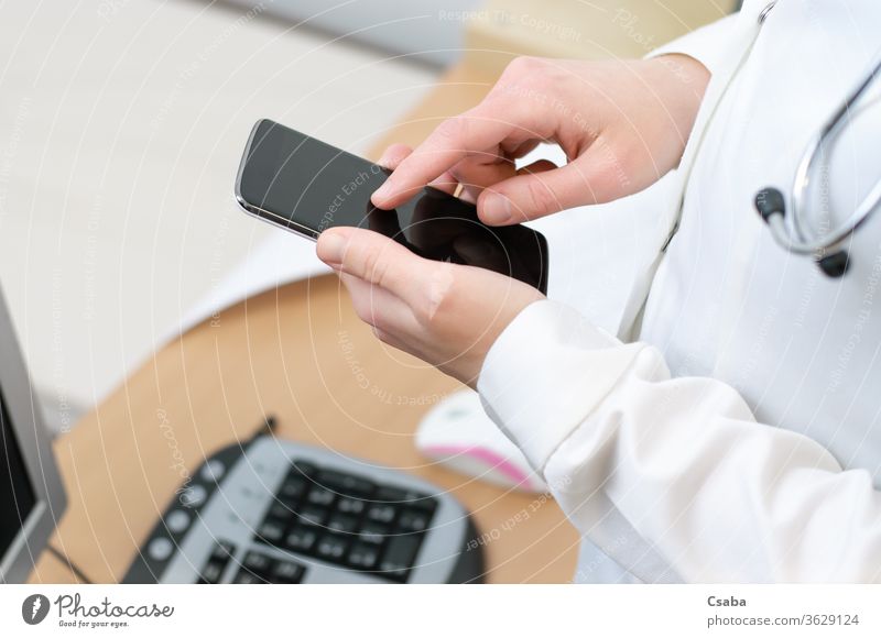 Eine Ärztin schreibt eine SMS auf einem Smartphone Arzt Frau Telefon Funktelefon benutzend Texten Tippen Nachricht Hand Beteiligung berührend Mobile Zelle