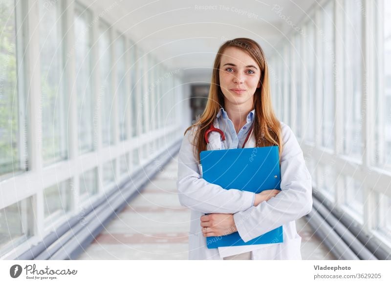 Ärztin über Klinikinterieurs Hintergrund. jung Frau Porträt weiß Lächeln Gesundheit Krankenhaus Praktikant Spezialist Arzt medizinisch Stethoskop Mädchen Job