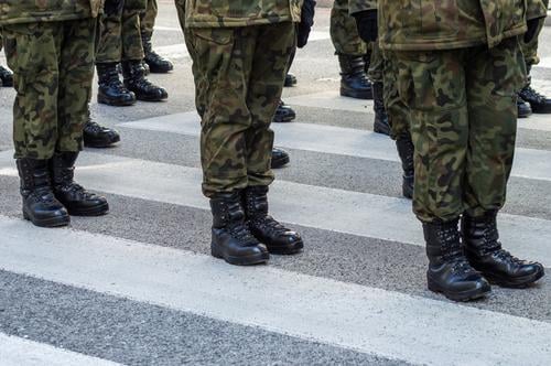 Auf der Straße stehende Soldaten in einer Militäruniform mit Tarnung und schwarzen Militärstiefeln Truppen Springerstiefel Bootcamp Zug Veteranentag Stehen