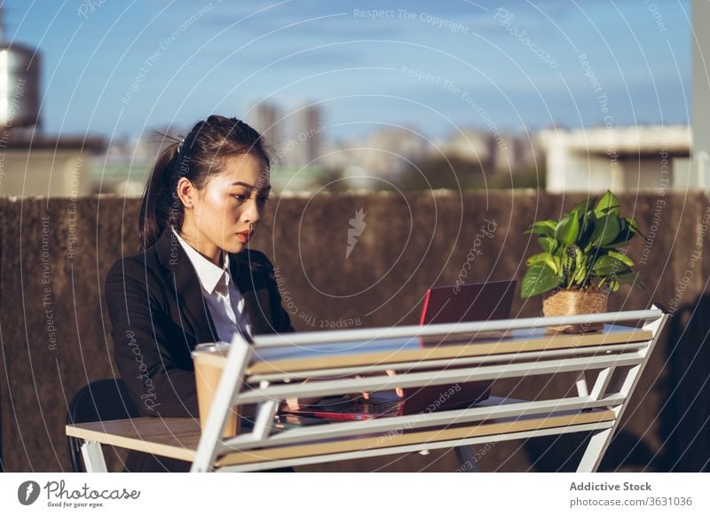 Geschäftige Frau mit Laptop arbeitet auf dem Dach Arbeit benutzend Geschäftsfrau formal Dachterrasse Gerät Apparatur Business asiatisch jung Internet