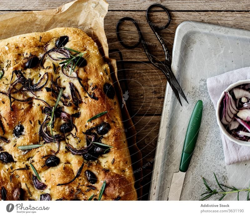 Focaccia mit schwarzen Oliven und Kräutern auf Holztisch hölzern Brot Hefe oliv italienisches Brot Focaccia-Brot Bestandteil handgefertigt Zwiebeln