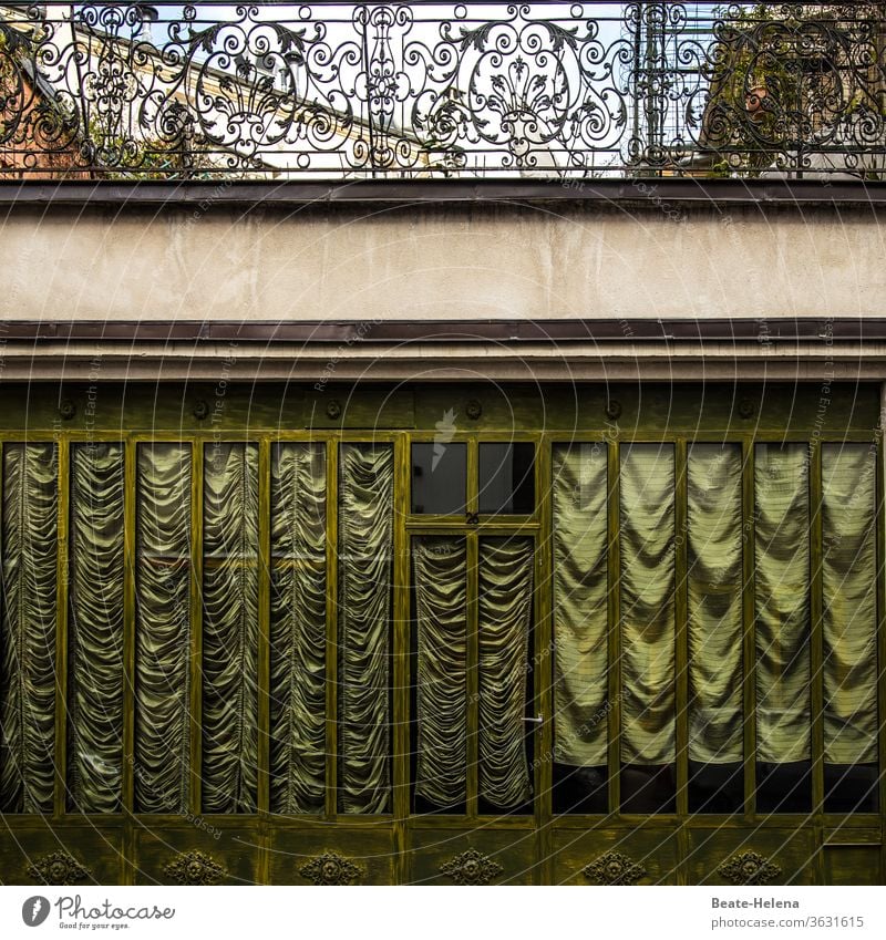 Alte Pracht: geraffte Glitzerstores und kunstvoll geschmiedete Balkongitter in Paris Chic Prun altmodisch glitzerglimmer Vorhänge Stores Gardine Fenster Tag