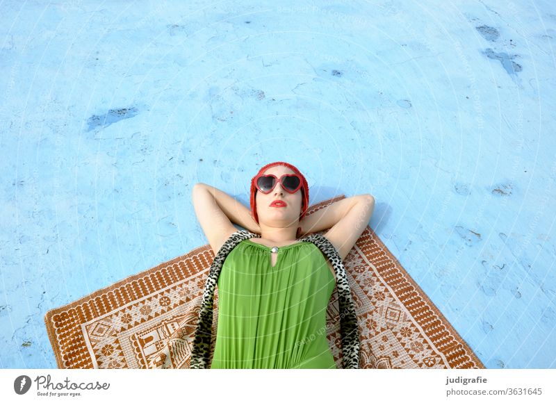 Das Mädchen mit der schönen roten Badekappe und grünem Badeanzug sonnt sich im leeren Nichtschwimmerbecken. Eine Sommerliebe. Frau Badebekleidung Badehaube Haut