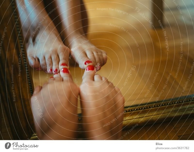 Füße mit rot lackierten Nägeln, die sich in einem Spiegel spiegeln rote Nägel Nagellack Pediküre Fußnägel Barfuß feminin Beine Haut Boden Fußboden Zehen Frau